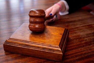 Close-up of a wooden judge's gavel on a desk in a courtroom, symbolizing justice.