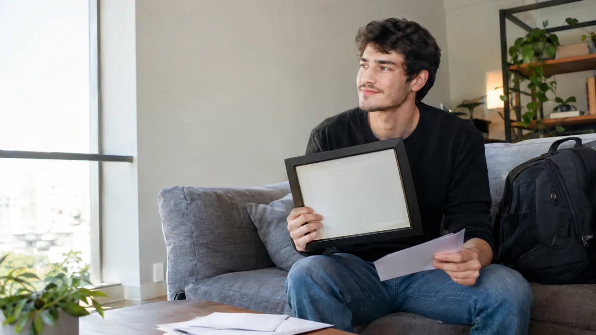 Jovem encerra conta universitária depois de terminar a faculdade e descobre anos depois uma dívida acumulada por serviços bancários Cena ilustrativa de contas universitárias e tarifas: jovem graduado em apartamento com diploma em moldura sem escrita, correspondência bancária genérica e mochila de faculdade ao lado